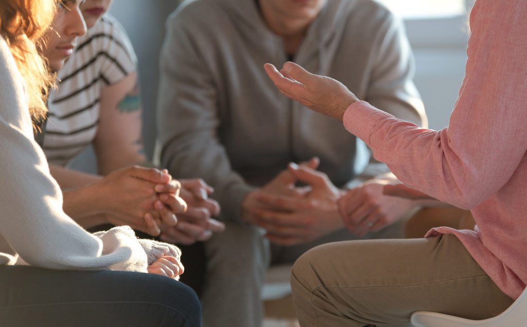 People gathered in a recovery community providing mutual support