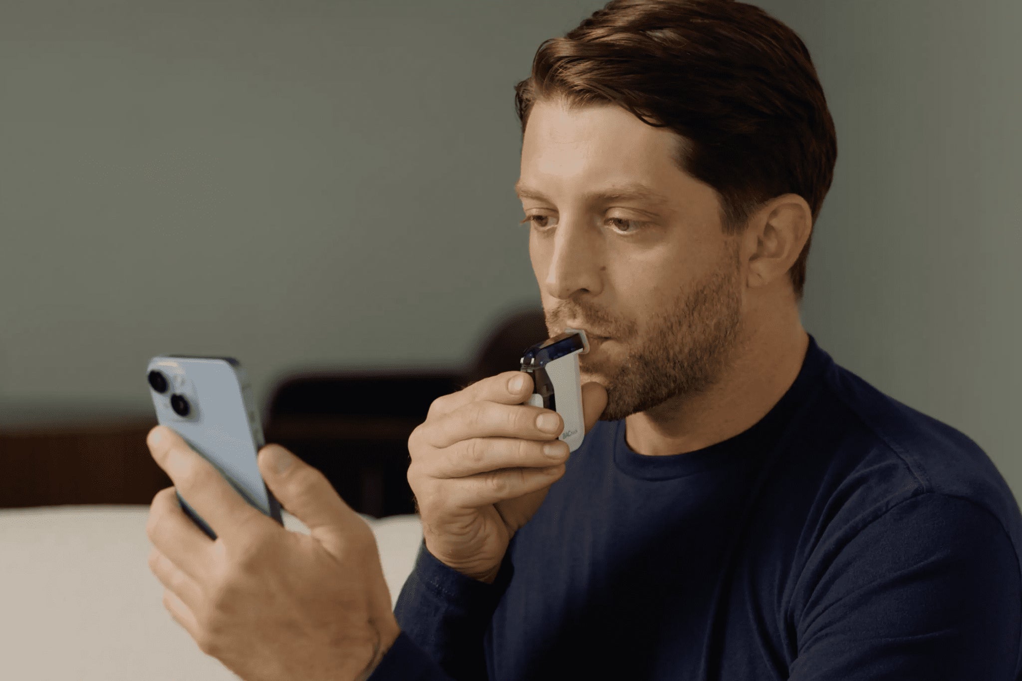 Man using BACtrack Mobile breathalyzer with BACtrack View app