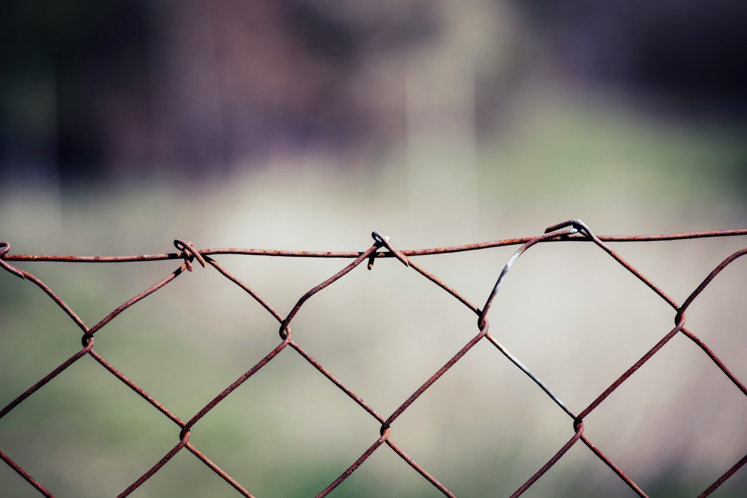 gray metal fence with barbwire representing idea of boundaries in article about codependency and addiction