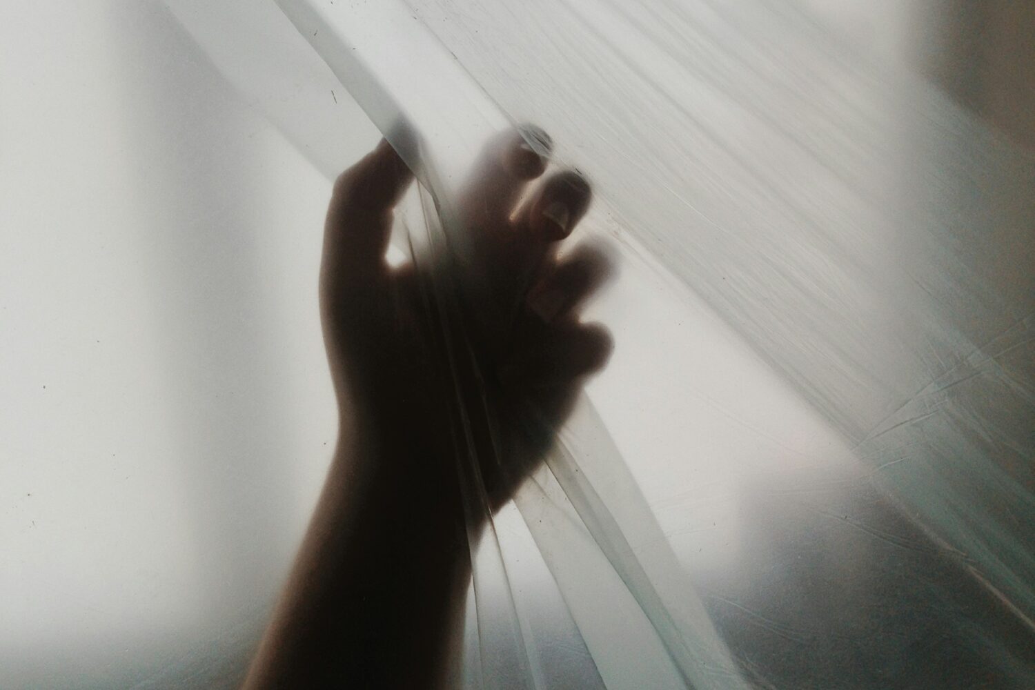 a person's hand reaching out of a window