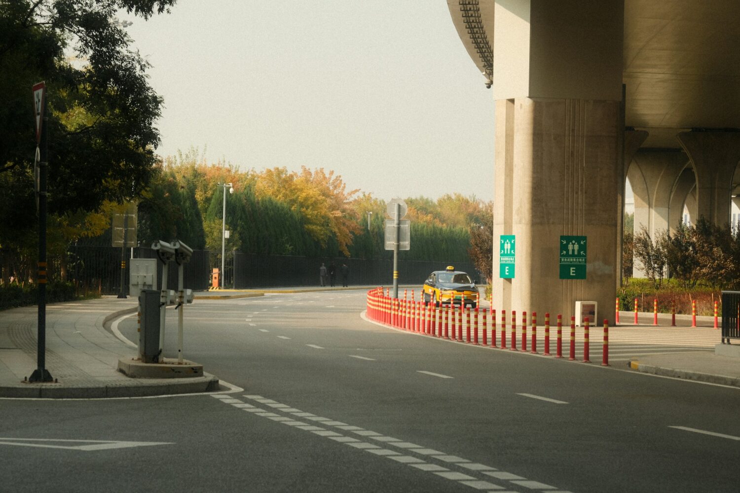 A car is driving down the road near a building